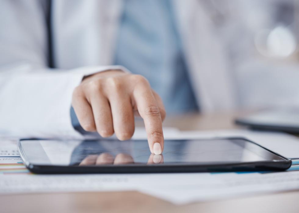 Female doctor's hand on a tablet.