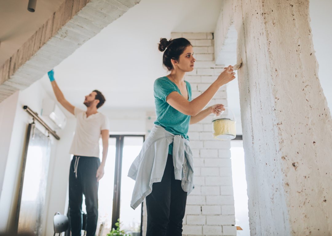 A man and woman painting the interior of a house.