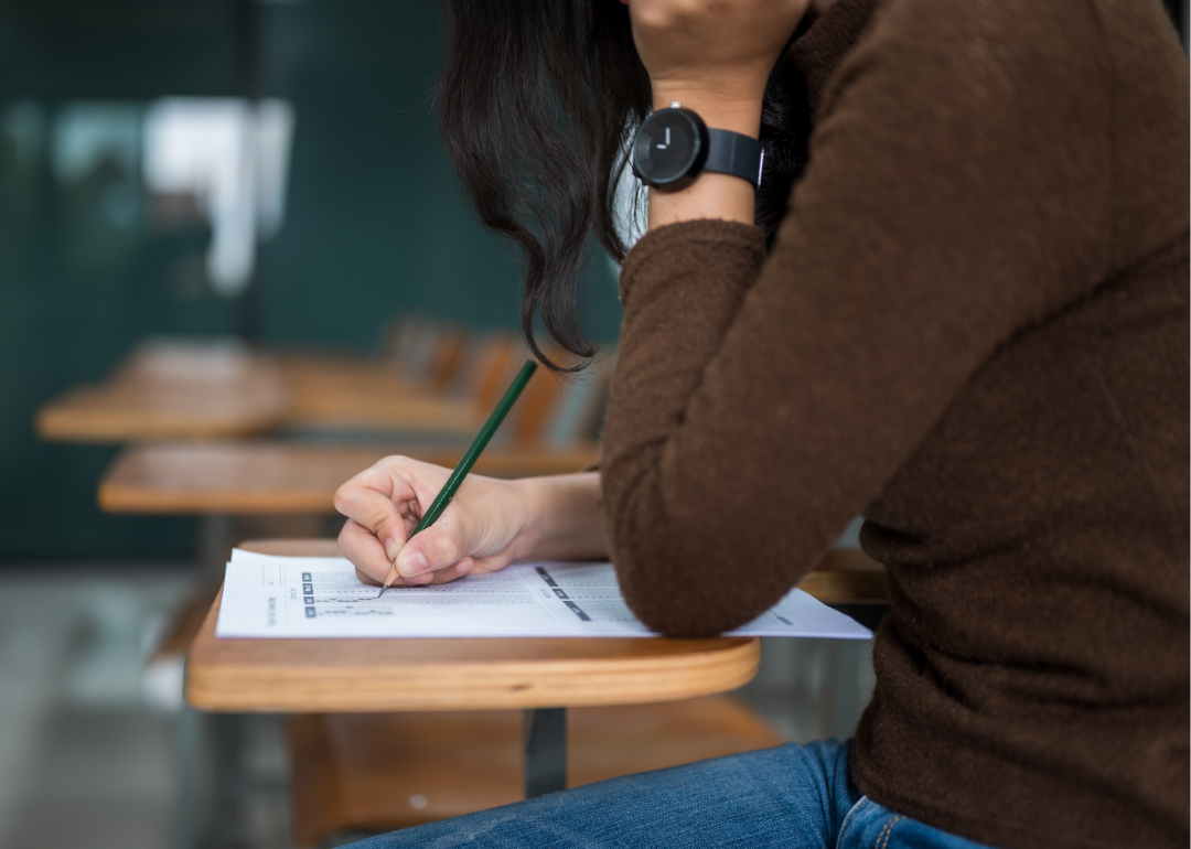 A female student takes a test at a desk