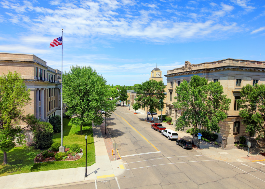 Historic buildings and an American flag on a small street in Grand Forks.