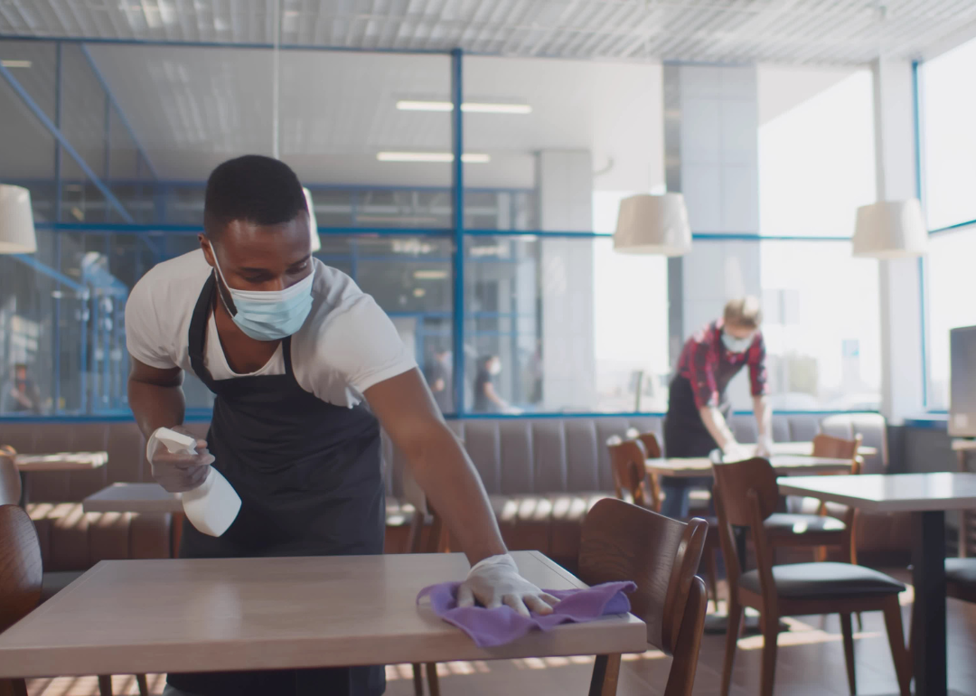 Cafeteria attendants cleaning tables