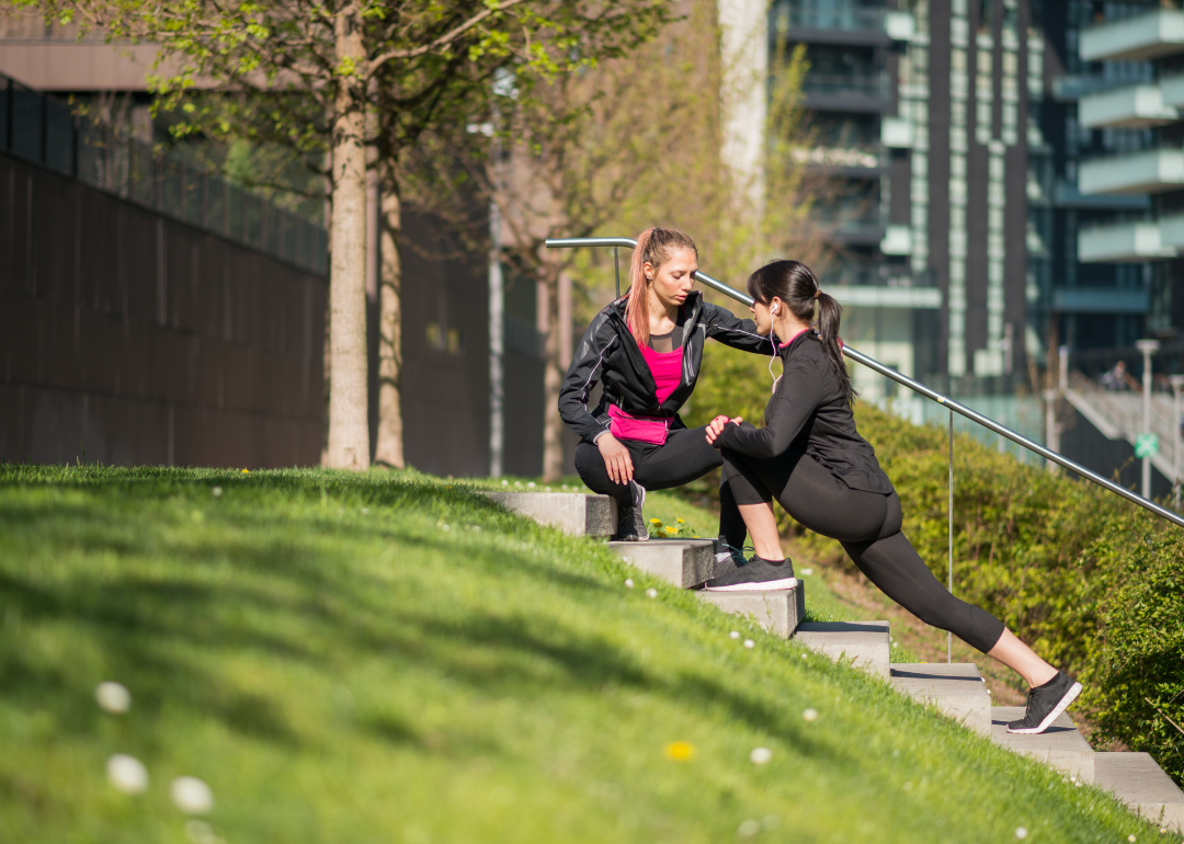 A personal trainer helping a client stretch