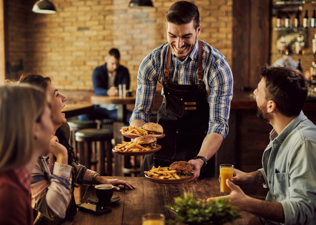 A waiter bringing food to a table