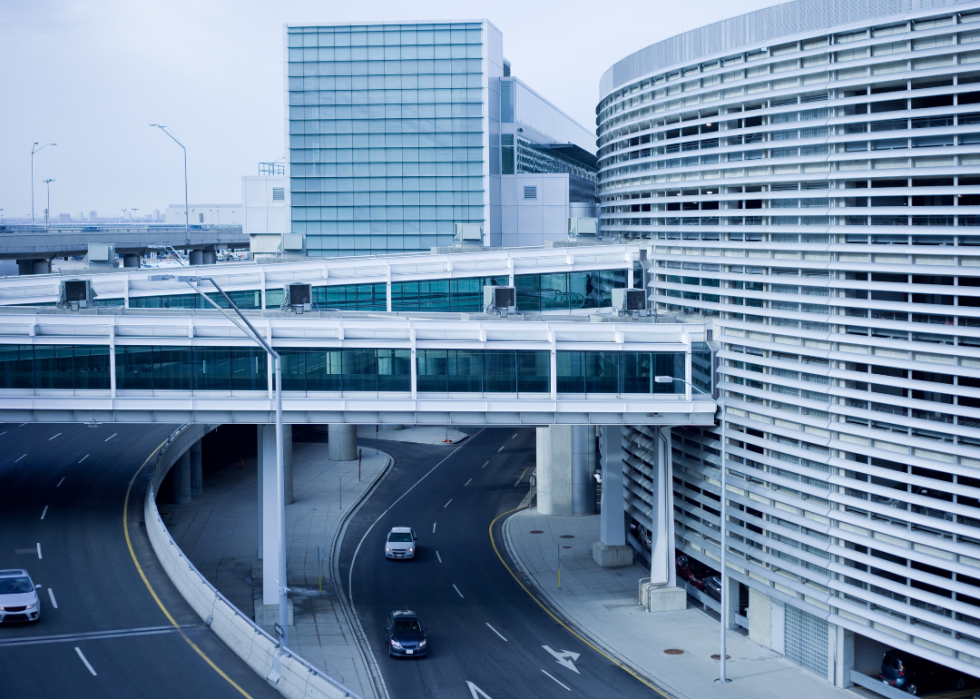 Modern white building with lots of windows and two skybridges across the road.