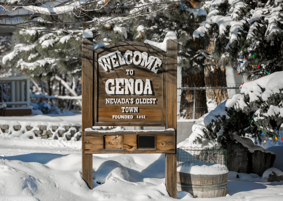 A wooden sign inviting people to Genoa.