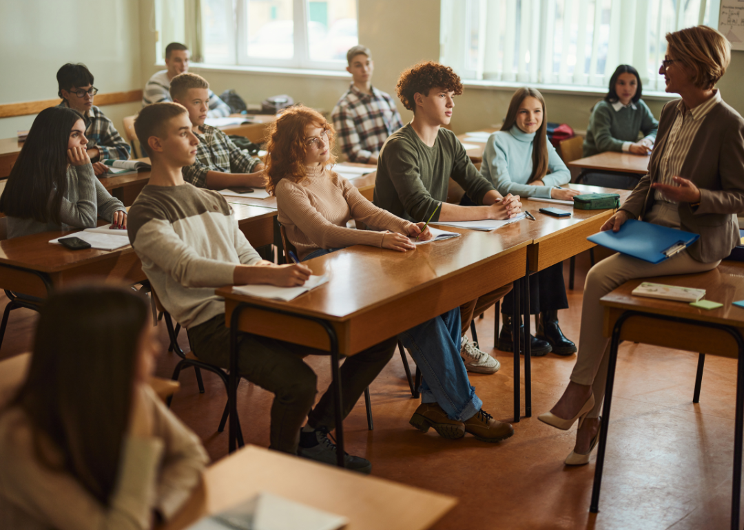 A high school class listening to their teacher.