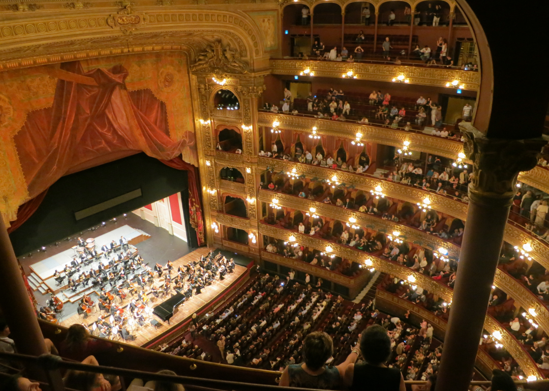 An orchestra performing in a larger theater.