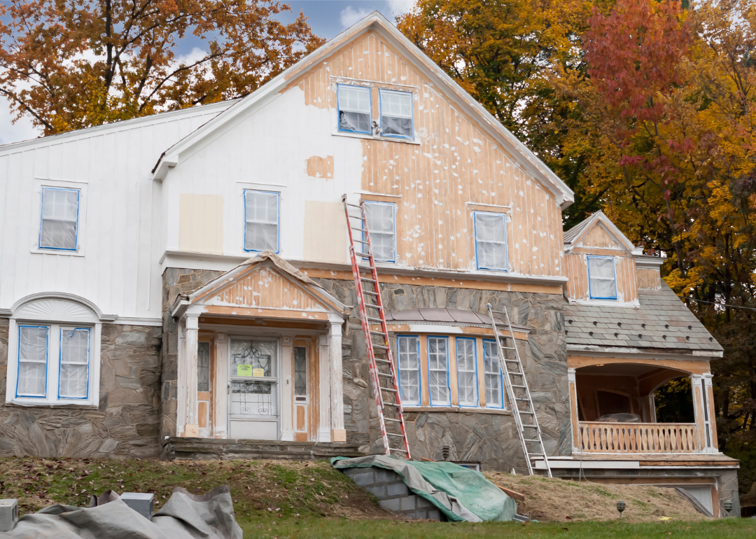 A home in the middle of having it's exterior paneling painted.