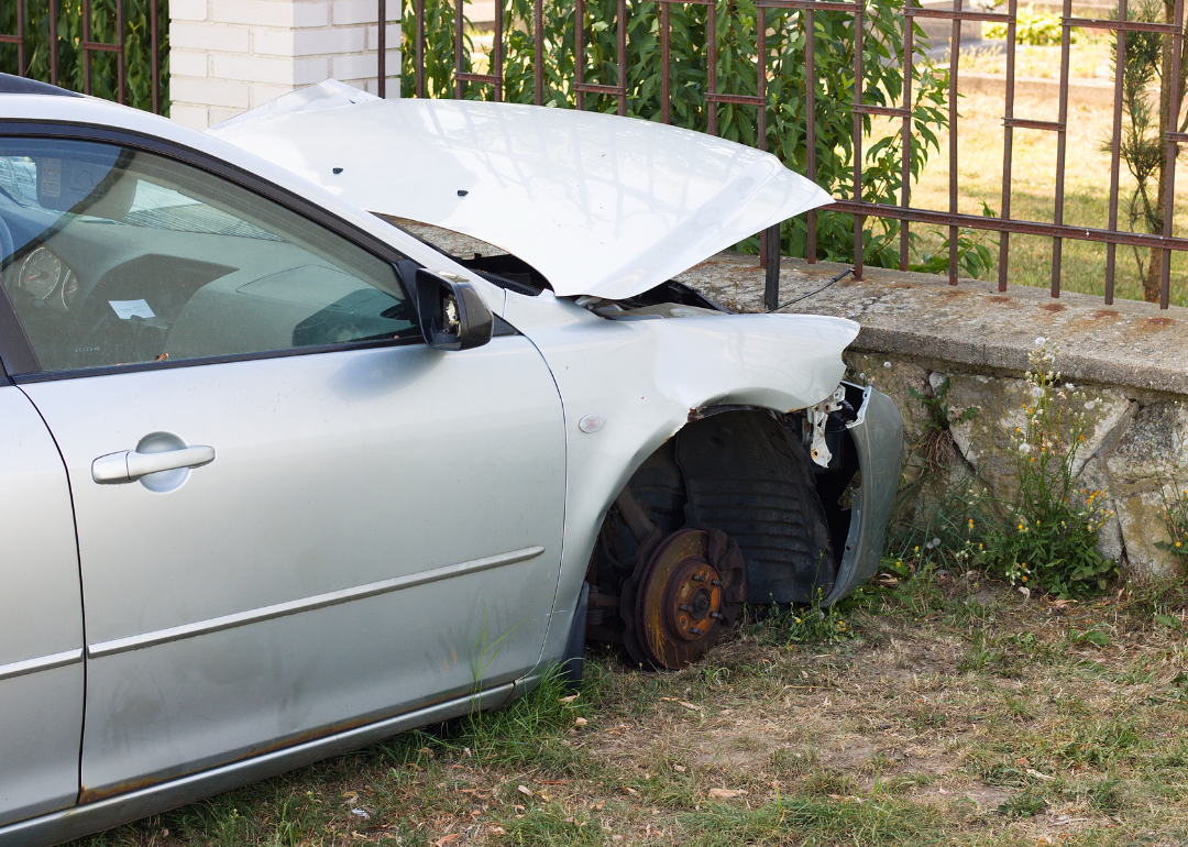 A car crashed into the fenced wall of a cemetery.