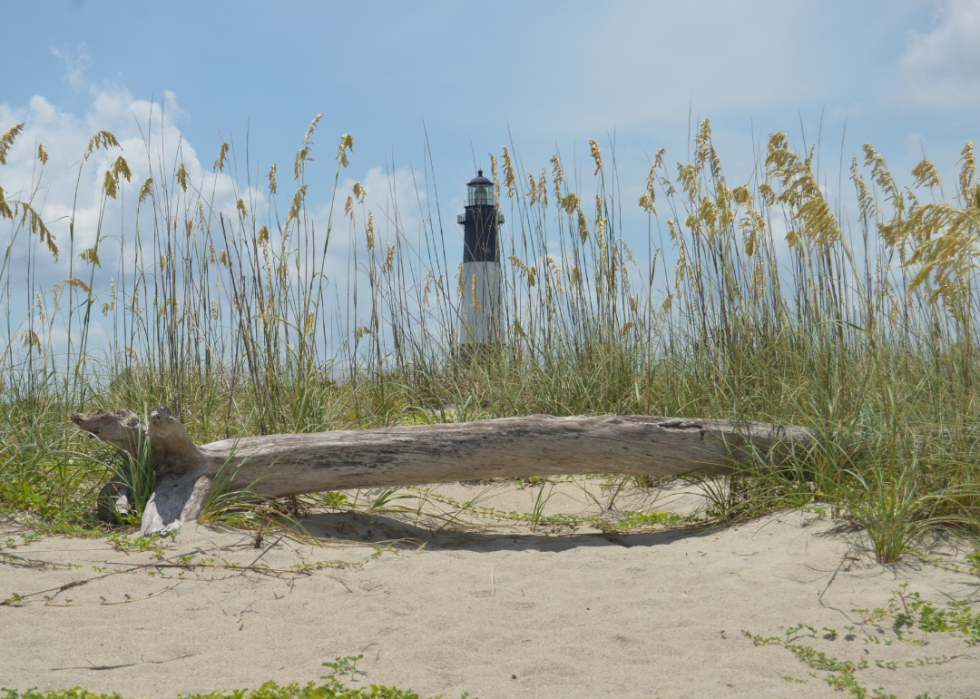 A Georgia beach with a lighthouse in the background on a summer day.