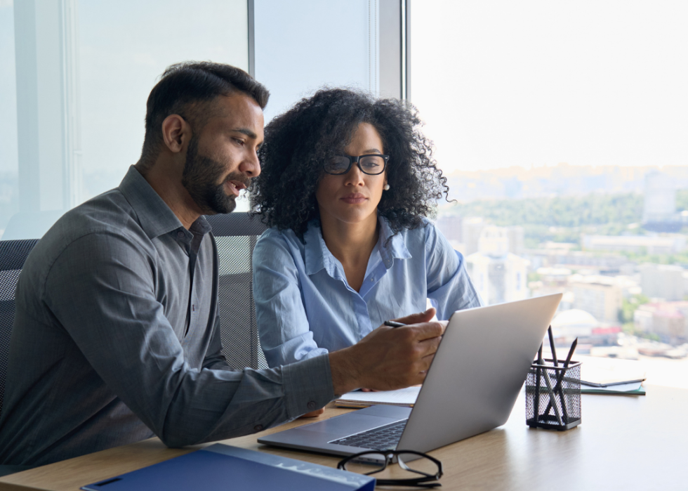 Two management analysts in conversation at an office