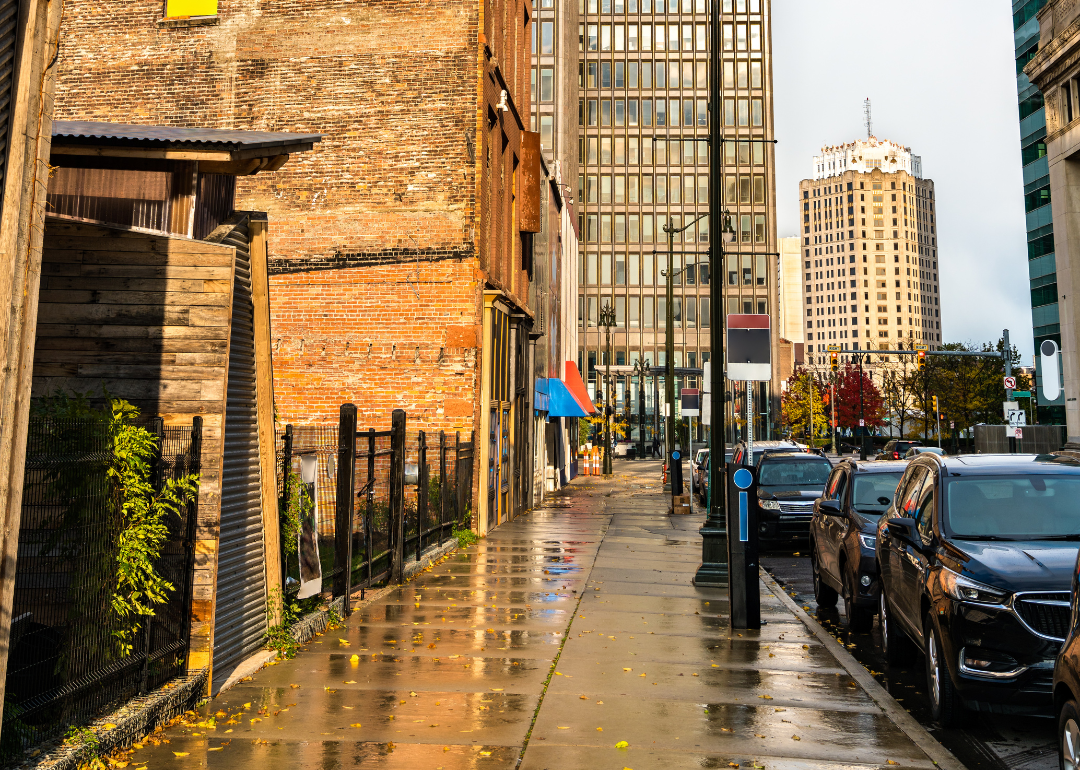 A street-level view of cars and historic buildings in Detroit.
