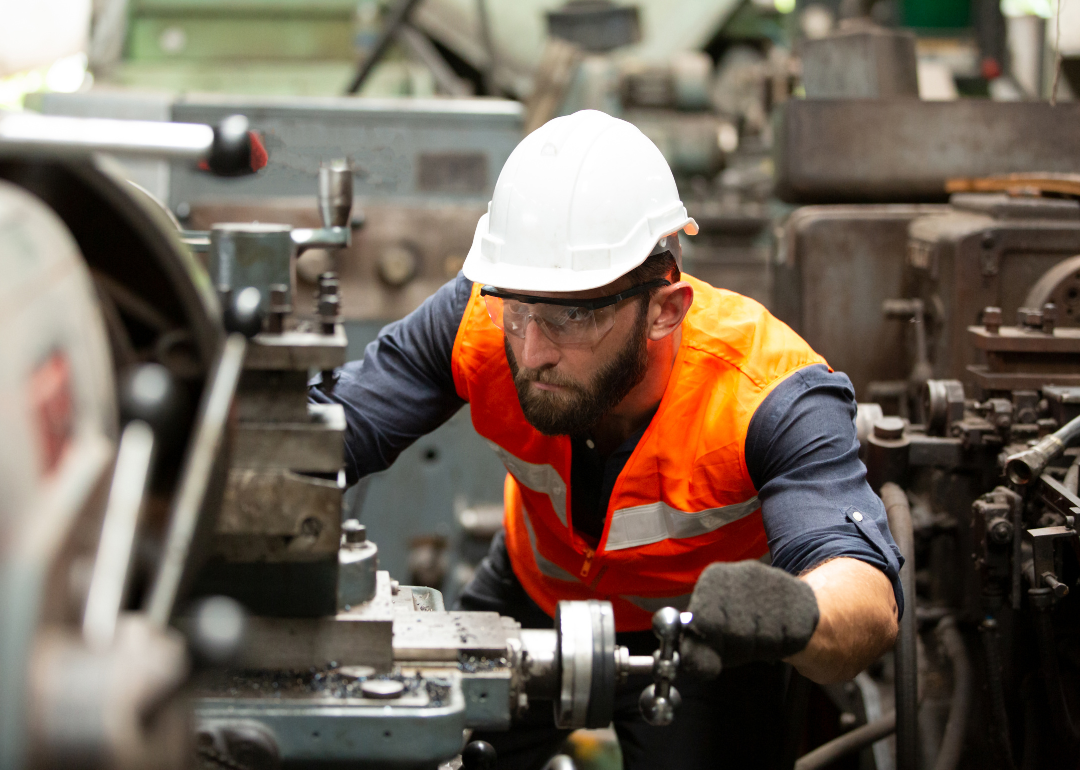 A manufacturing engineer operating machinery at a factory.