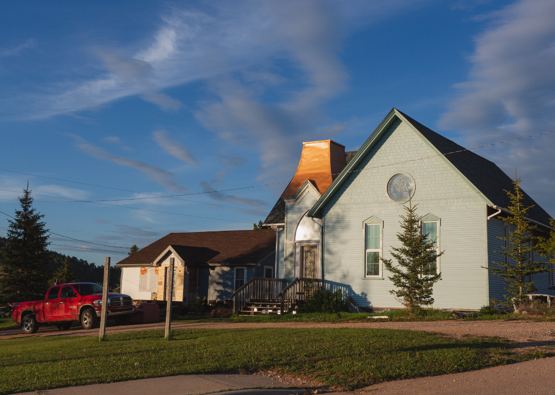 A home in Wyoming with a red truck parked outside it.