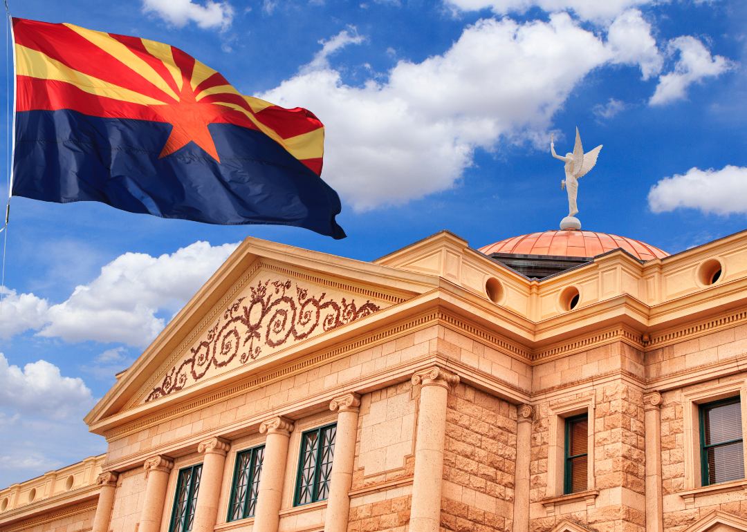The Arizona State Capitol with the state flag in the foreground.