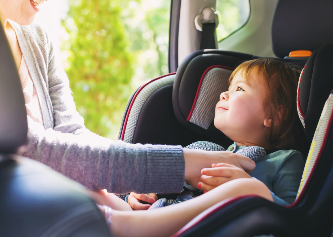 A toddler strapped into a car seat.