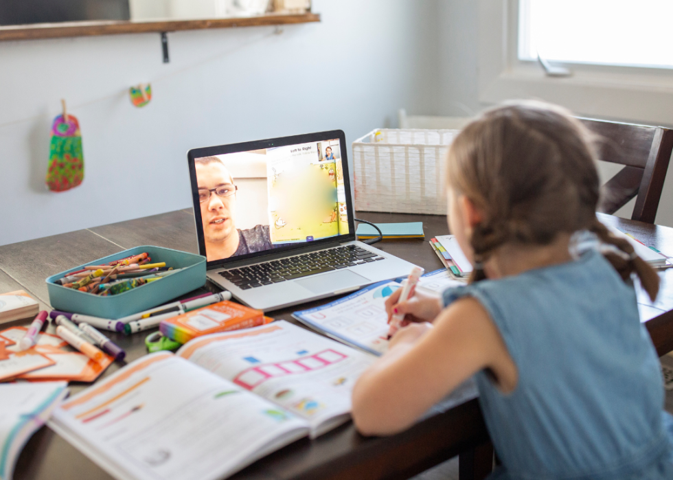 A young girl using her laptop to learn remotely