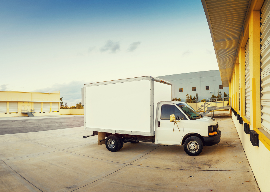 A light truck parked in front of a storage locker.