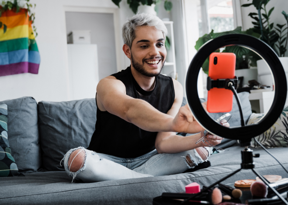 An influencer does his makeup while sharing products with his viewers