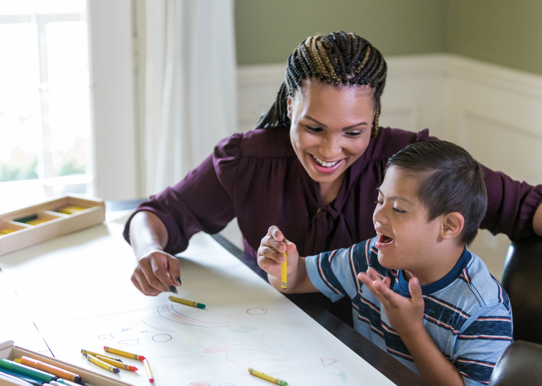 A teacher working with an excited special needs student.