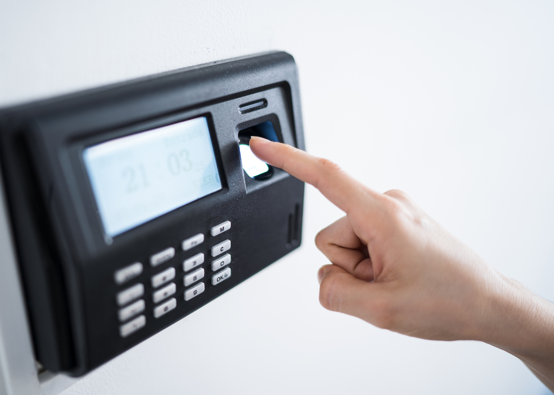 A person's fingerprint being scanned by a biometric clock-in system