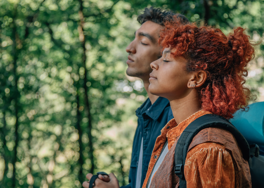 Two people breathing deeply in the woods.