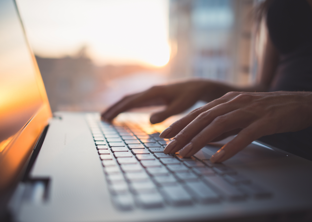 A person's hands on their computer's keyboard