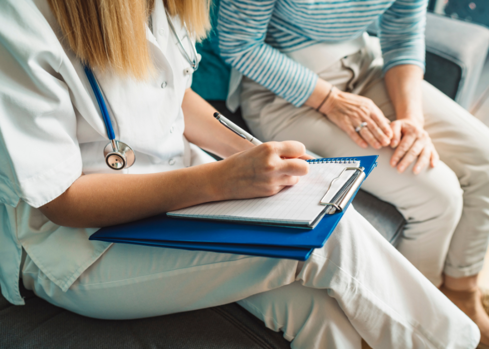 A nurse writing data on a medical chart