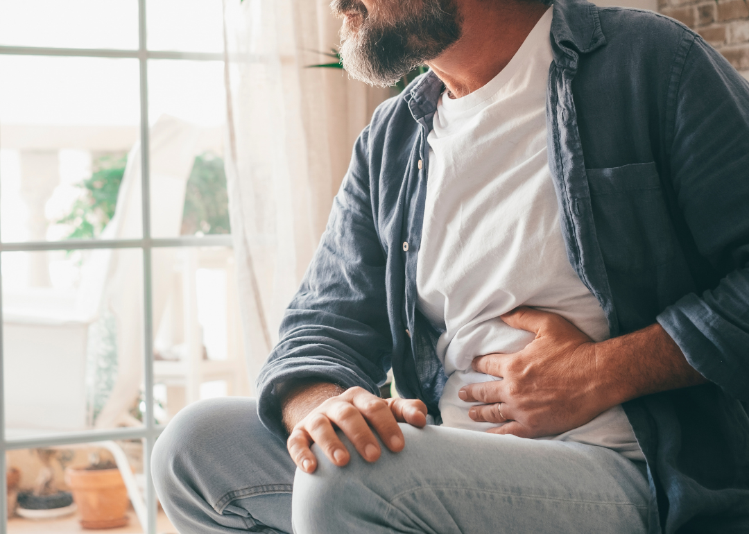 A person grabbing their stomach in pain.