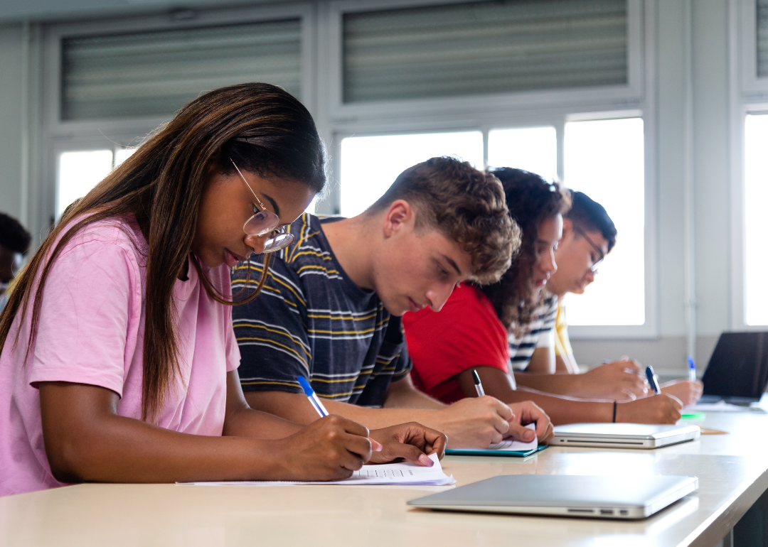 Students sitting at their desks and writing in class.