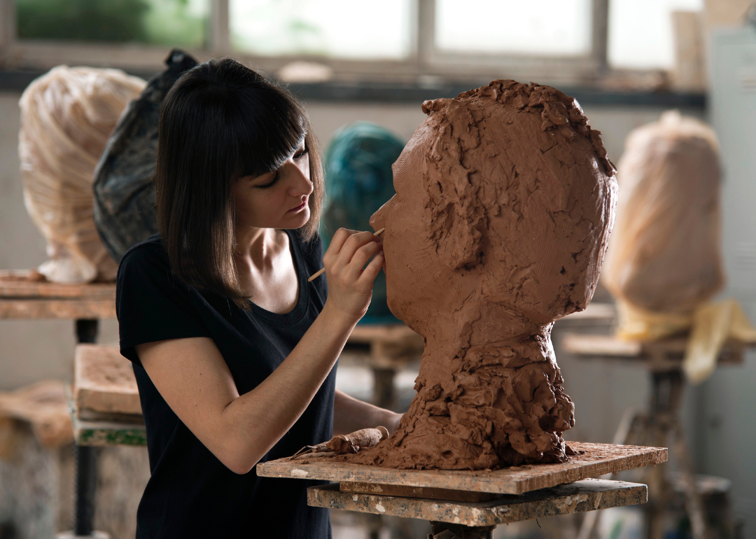 A student sculpting a bust.