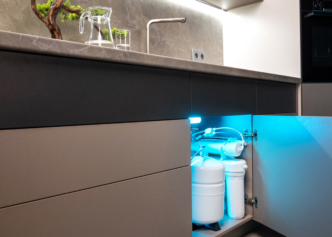 A house's water filtration system located under the kitchen sink.