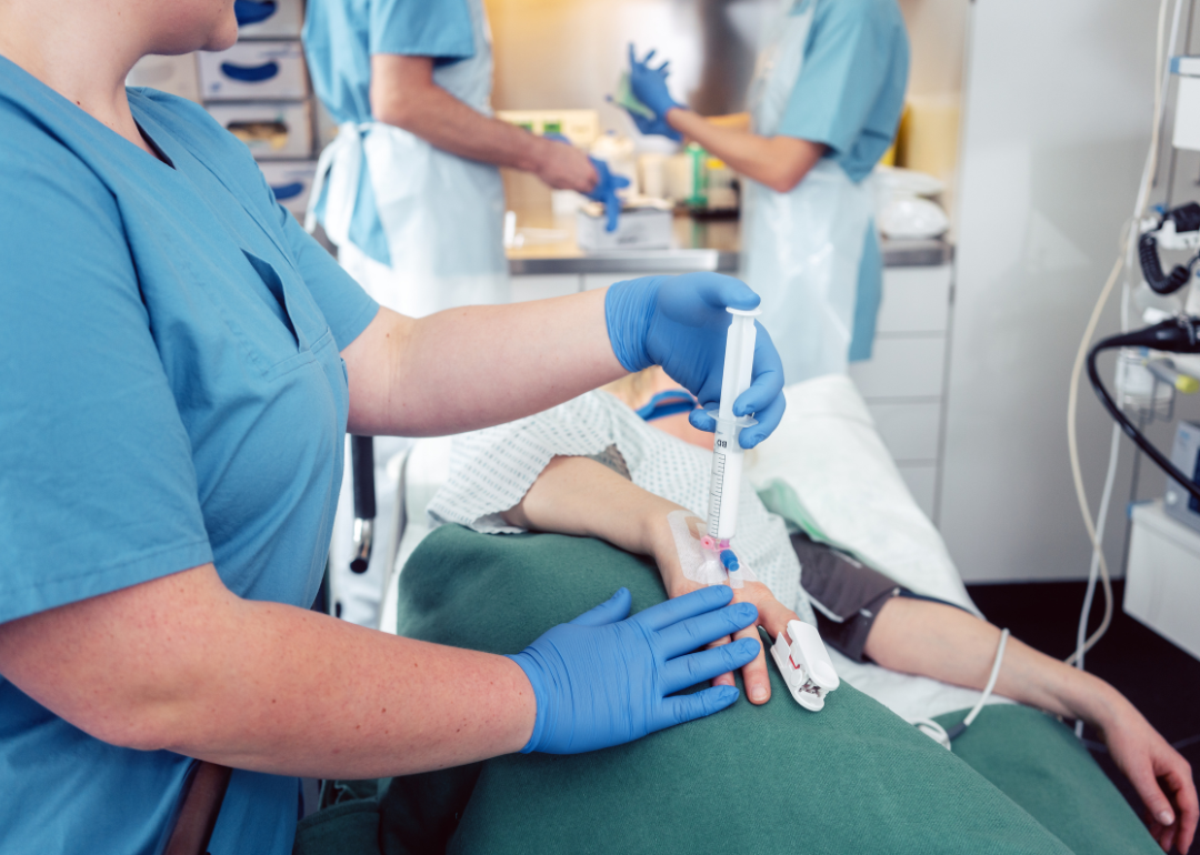 A nurse giving anesthesia to a patient.