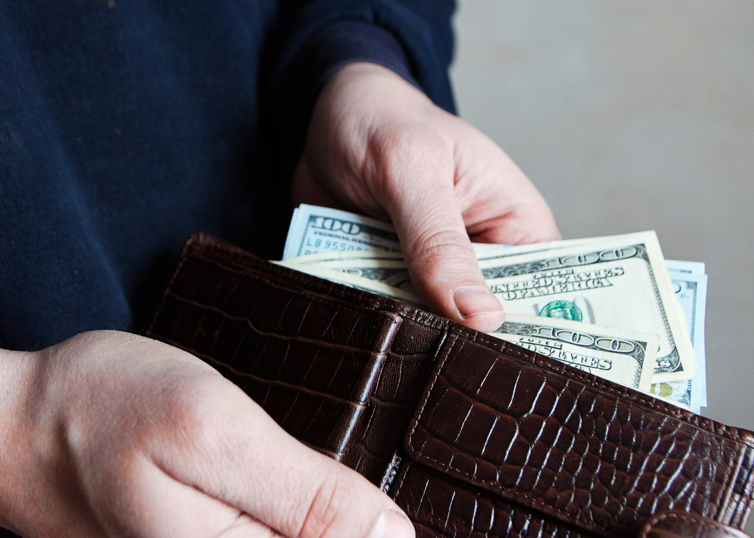 A person taking money out of their wallet.