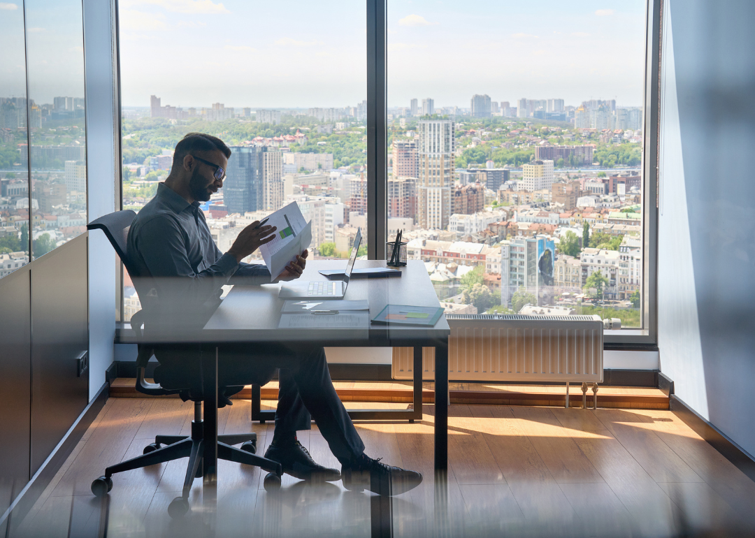 A credit analyst reviewing paperwork in their office
