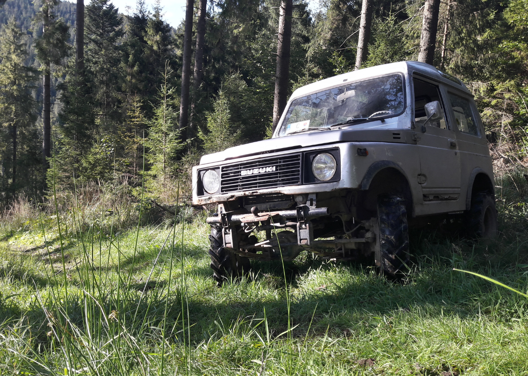 A Suzuki Samurai parked in a mountain area.