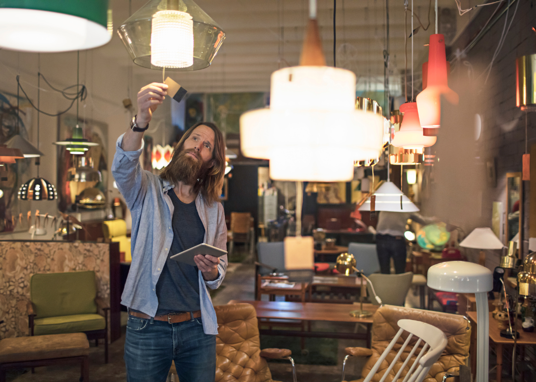 A person reading a price tag in a furniture store.