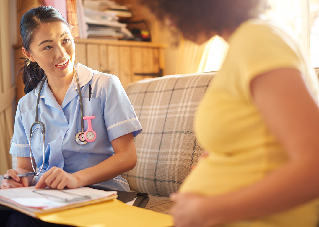 A nurse midwife giving advice to a pregnant patient.