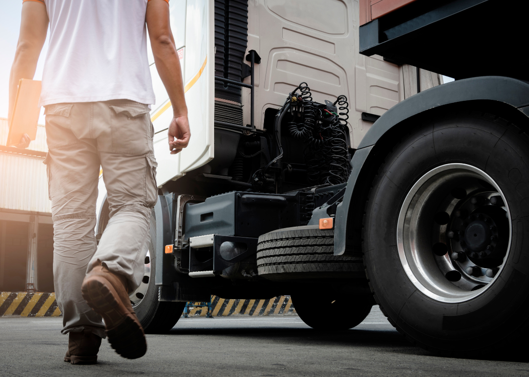 A driver walking towards a semitruck.