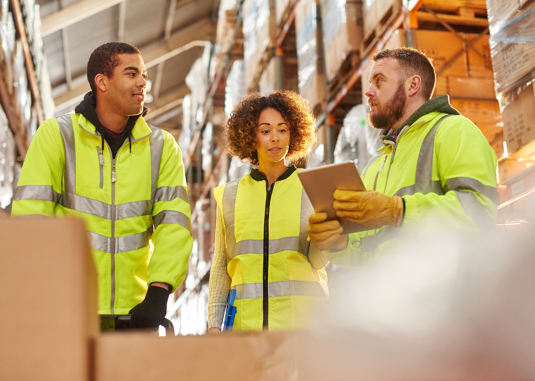 Warehouse workers speaking with a supervisor.