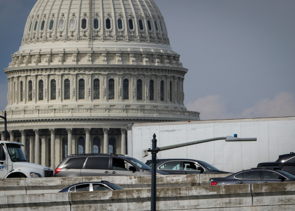 Traffic moving slowly on the highway with the background of the Capitol Hill in D.C. 