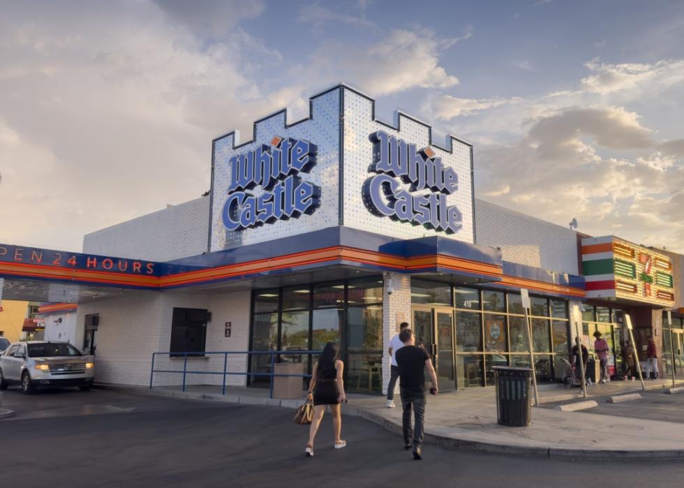 Exterior of White Castle and two people walking toward it.