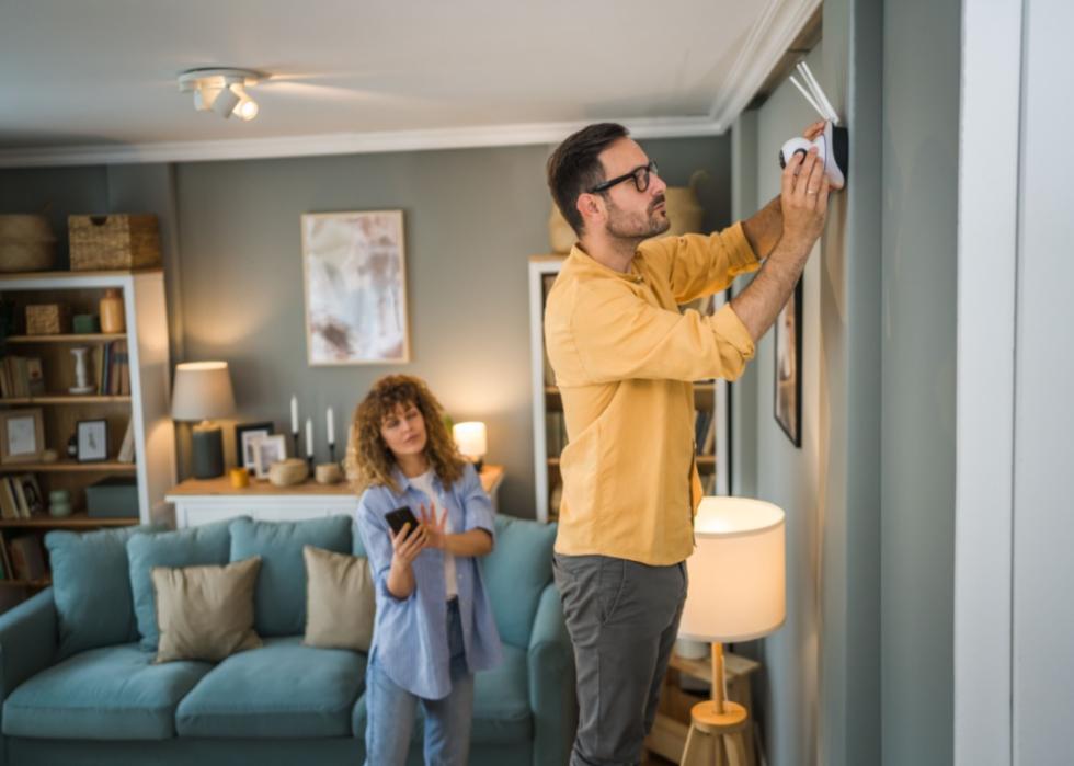 A couple installing a camera in their home.