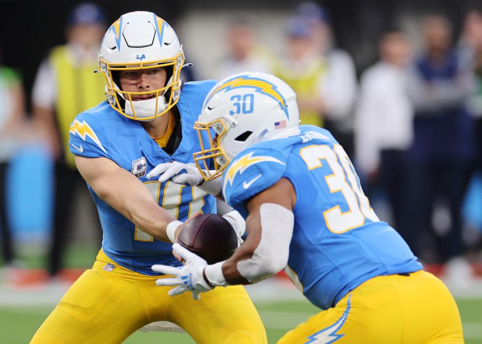 Justin Herbert hands off to Austin Ekeler of the Los Angeles Chargers in the first half against the Dallas Cowboys at SoFi Stadium on Oct. 16, 2023 in Inglewood, California.