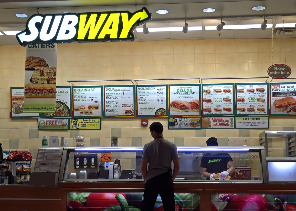 Someone ordering a sandwich at a Subway.