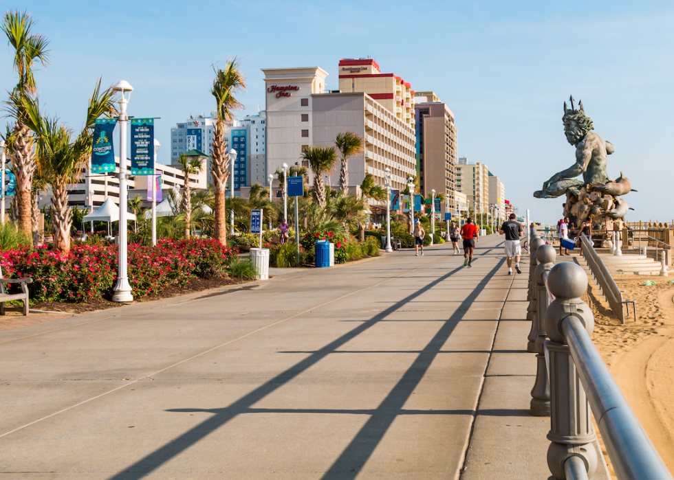 A boardwalk on the water with a statue of Neptune on the side.