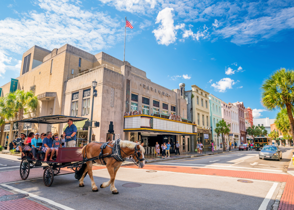 People being pulled in a horse-drawn cart in Charleston.