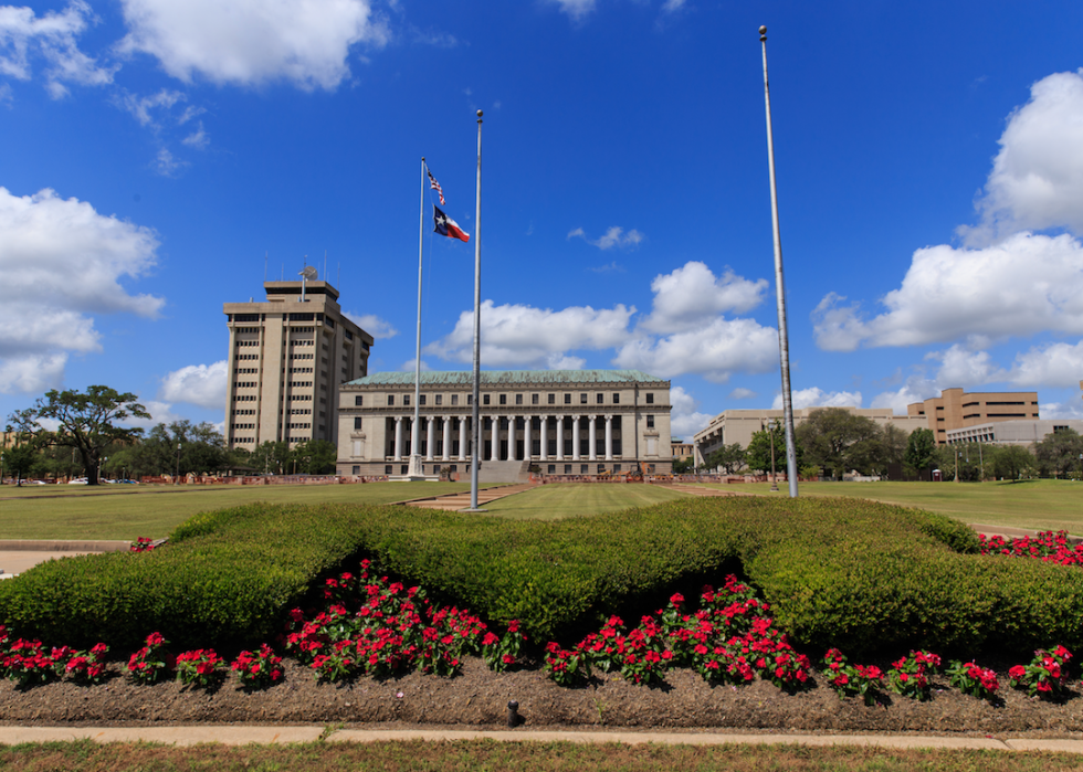 A large rectangular building with columns in the front and a green lawn.