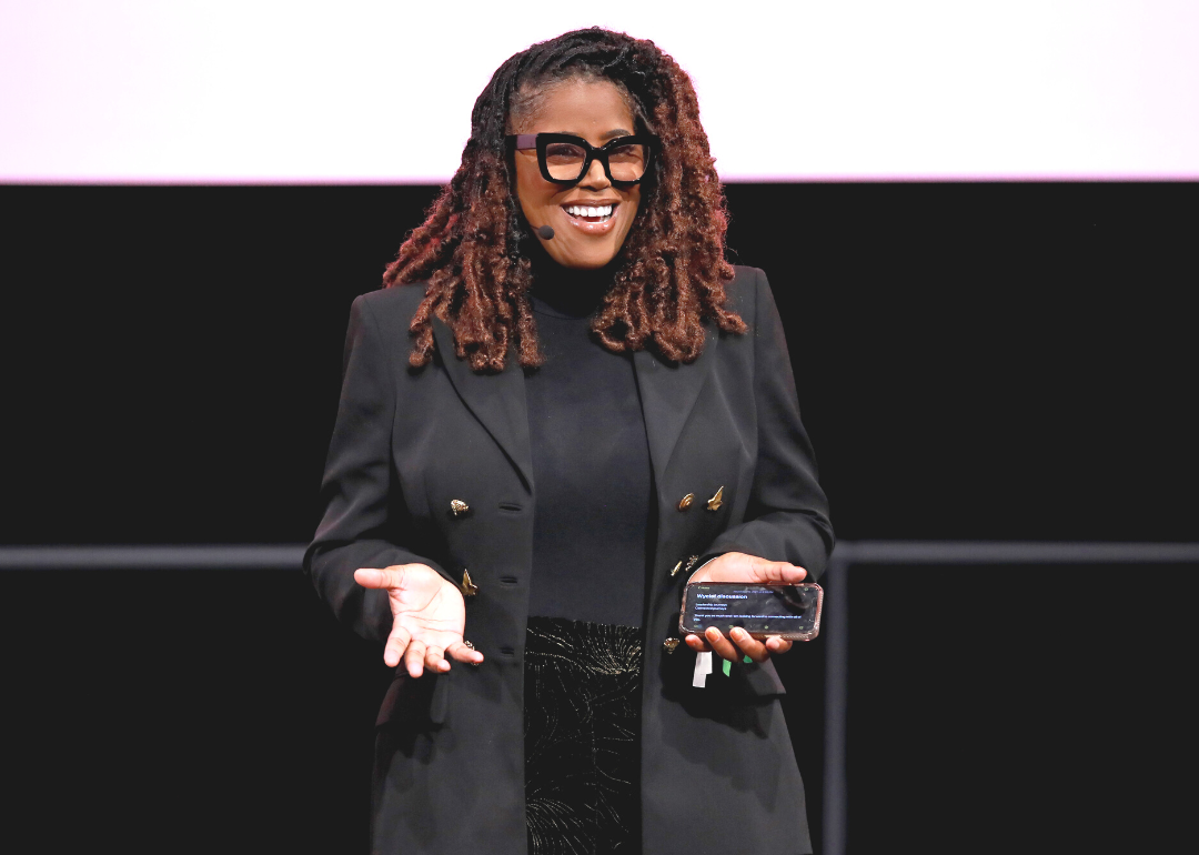 Thasunda Duckett presenting in front of a black and pink background.