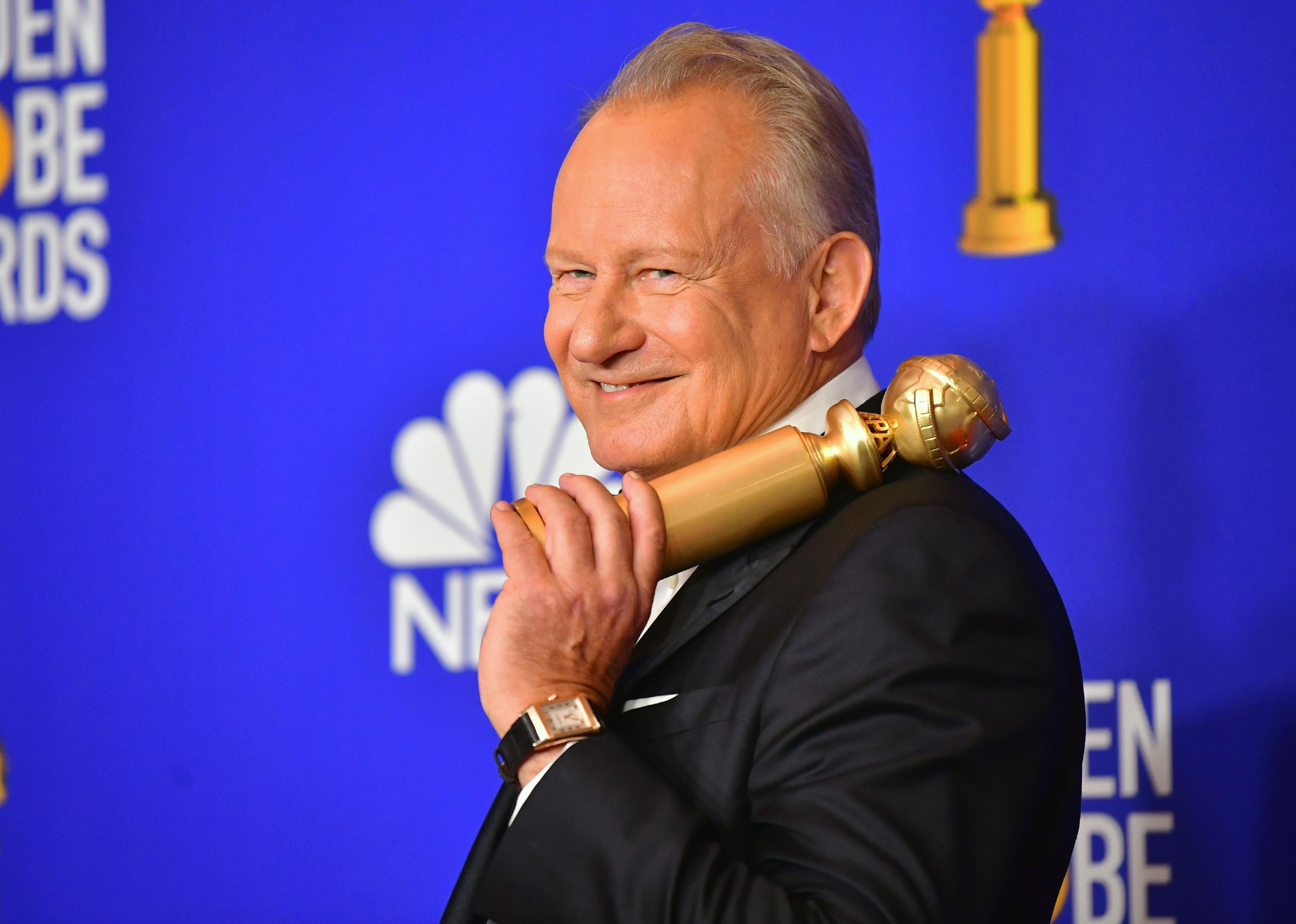 Stellan Skarsgård holding a golden globe.